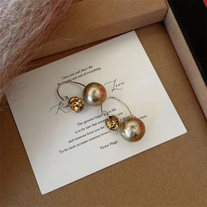 Detail of luxury snowflake bead earrings with zircon tassels on a decorative card