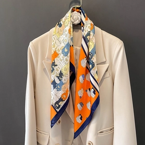 Elegante foulard in seta con stampa gatto arancio e blu su un blazer beige chic