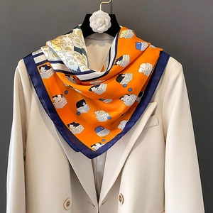 Foulard di seta quadrato con gatti in arancione e blu navy su un blazer beige