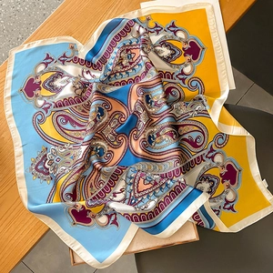 Close-up of vibrant paisley print silk scarf with luxury yellow and blue patterns