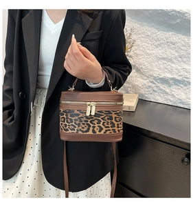 Detail of leopard print panel on bucket bag with gold hardware and leather handle