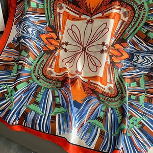 Detailed view of colorful ethnic pattern print on soft silk scarf with natural drapery