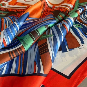 Detailed macro view of the silky texture and artistic colorful print on the long scarf