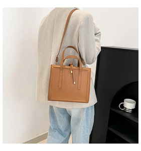 Caramel brown square tote bag with decorative straps shown in a lifestyle setting