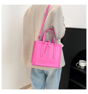 Detailed view of a hot pink tote bag on model showing a structured rectangular shape