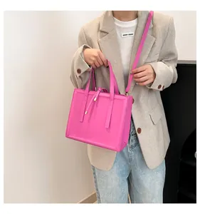 Magenta leather crossbody bag styled with a textured blazer and casual jeans