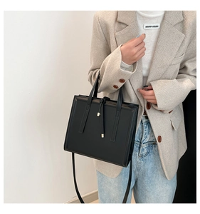 Chic black square tote bag in smooth leather texture styled with casual blazer and jeans
