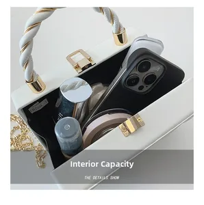 Top view of the interior capacity of a white chain box bag with phone and cosmetics