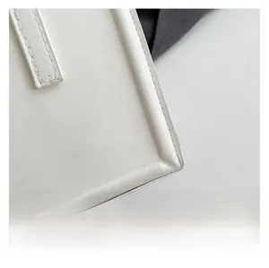 Close-up of white leather handbag featuring premium stitching and fine texture details