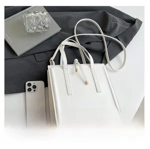 Detailed top view of a minimalist white leather square tote bag with elegant metal hardware