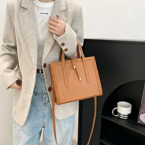 Elegant caramel leather crossbody bag with dual handles and structured rectangular shape