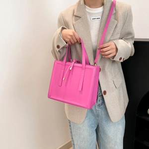 Pink glossy faux leather square tote bag with top handles and adjustable shoulder strap