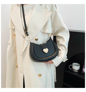 Détail du sac hobo noir avec boucle magnétique cœur dorée et texture en similicuir mat élégant