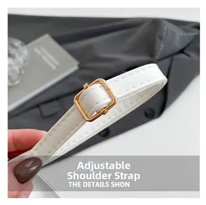 Close-up of white leather adjustable strap with gold square buckle and neat stitching
