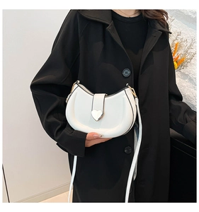Détail du sac bandoulière demi-lune blanc avec boucle cœur argentée et texture en cuir PU
