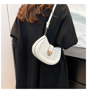Détail du sac à main blanc en demi-lune avec boucle cœur dorée et bandoulière fine