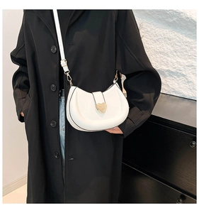 Détail du sac bandoulière blanc demi-lune avec boucle en métal doré en forme de cœur