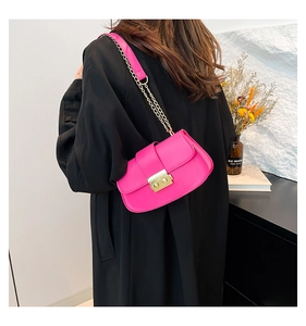Vue détaillée du sac à rabat magenta avec chaîne dorée et texture en cuir synthétique PU