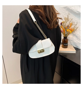 Détail du sac baguette en cuir PU blanc avec fermoir doré et bandoulière chaîne