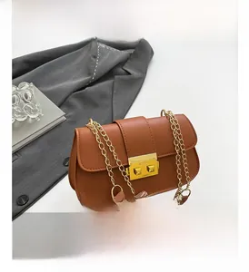 Détail du sac en similicuir marron avec bandoulière chaîne dorée et fermoir carré