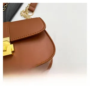 Détail du sac en cuir PU marron avec fermoir rotatif en métal doré et sa chaîne