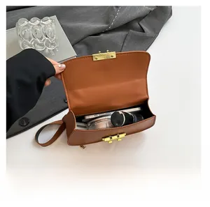 Vue intérieure du sac bandoulière marron montrant la capacité pour téléphone et maquillage