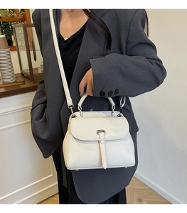 White lychee leather shoulder bag on grey suit model for a modern commute style