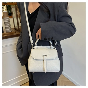 Close-up of white lychee pattern leather handbag with silver hardware and top handle