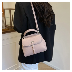 Detail of pink lychee leather handbag showing texture and detachable shoulder strap
