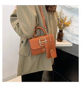 Caramel pebble leather handbag detail with detachable mini pouch and gold buckle