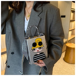 Silver box clutch bag with cartoon girl print and striped scarf handle on a grey suit