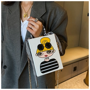 Close-up of a white box evening bag with cartoon girl print and silk scarf handle detail