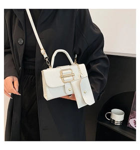 Detail of white litchi pattern bag with large gold buckle and matching small pouch