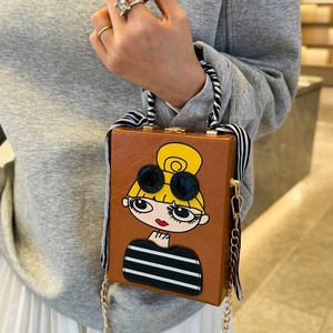 Brown box evening bag with cartoon face design, silk scarf handle, and gold chain strap