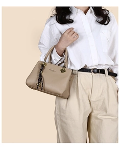 Detail of apricot tote bag with fashion leather lettering and textured ribbon handle