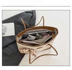 Interior view showing the large capacity of the beige woven tote bag with daily essentials