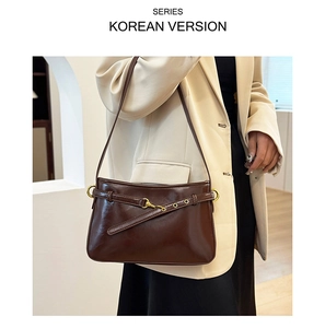 Détail du sac sous l'aisselle en cuir marron foncé avec boucle en métal doré