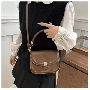 Detail of vintage brown leather square bag with gold twist lock and fine stitching