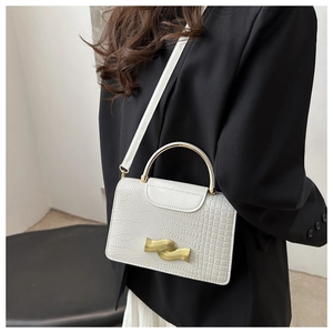 Detail of white embossed leather handbag with gold wavy buckle and curved metal handle