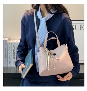 Detail of pink lychee leather bucket bag with decorative knot and metal buckle