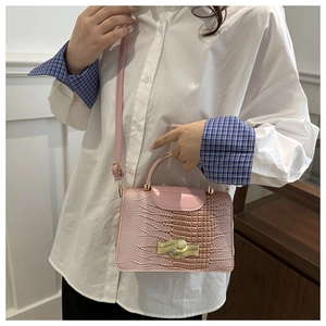 Pink faux lizard skin small square bag featuring a gold wavy lock and metal top handle