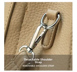 Detail of silver metal hook and pebble grain leather texture on a khaki bucket bag