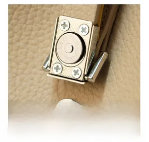 Detail of warm beige lychee leather bag with silver magnetic snap and serial number