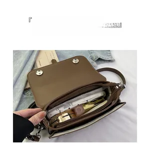 Detail view of the brown vintage crossbody bag interior with dual magnetic closures