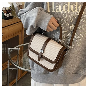 Detail shot of vintage patchwork handbag with canvas and brown leather trim on a model