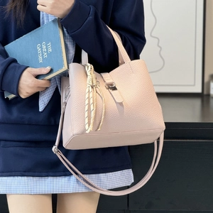 Chic pink pebble leather bucket bag with top handle and crossbody strap for women
