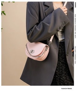 Detail of pink semi-circle saddle bag with silver chain strap and metal swivel lock closure