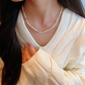 Collier double rang élégant avec perles blanches et perles argentées porté par un mannequin
