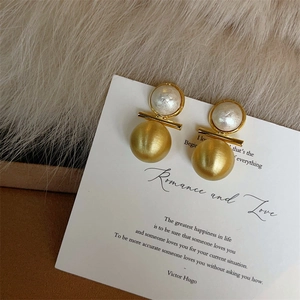 Vue détaillée de boucles d'oreilles boules bicolores avec perle et fini or mat