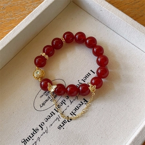 Détail du bracelet en agate rouge de 12mm avec breloque papillon sur boîte à bijoux